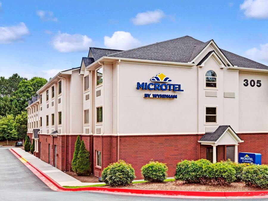 Un hotel Microtel by Wyndham con fachada de ladrillo, número 305, y una señal.