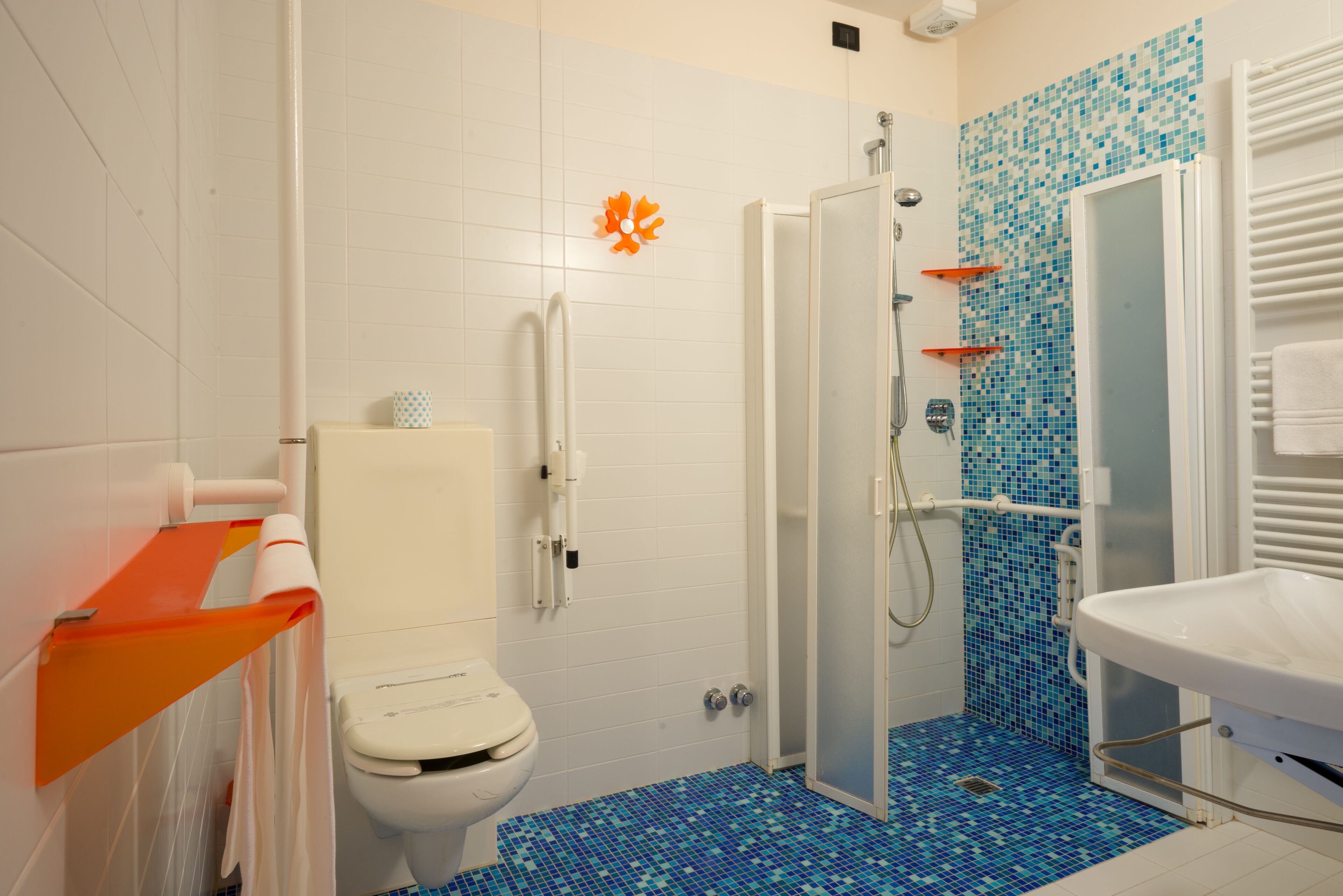 A bathroom with a toilet, shower, and sink.