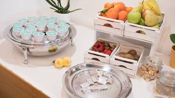 Un tavolo per buffet con diversi cibi, tra cui frutta, pasticcini e frutta secca.