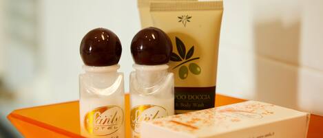 Two bottles of hair care product, a body wash, and a box of soap on an orange tray.