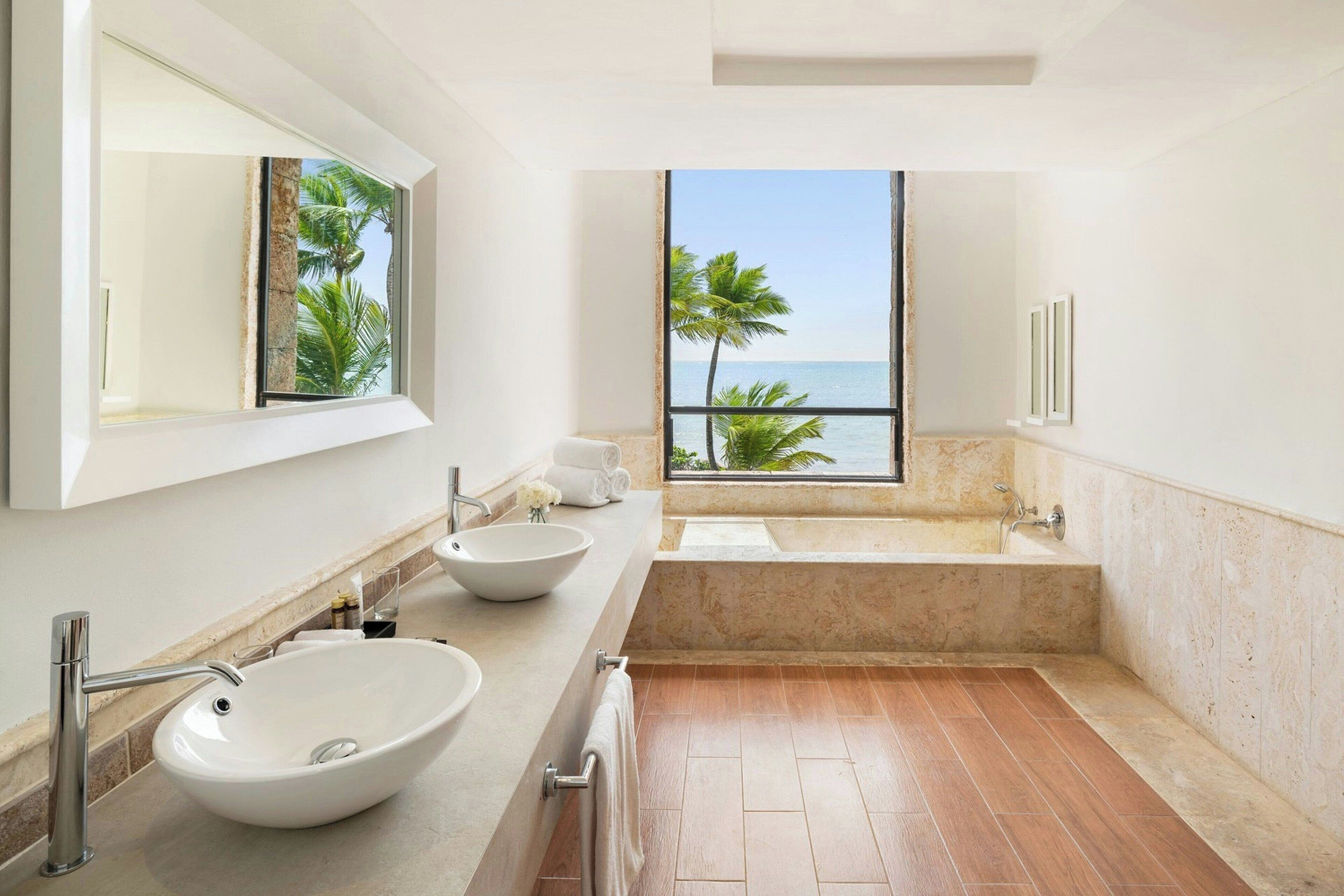 Ein modernes Badezimmer mit einem großen Fenster, einer Badewanne und zwei Waschbecken.