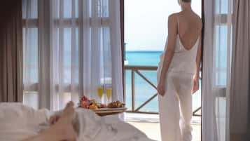 Enjoy a seaside view from the comfort of your room, where a delicious breakfast awaits on the bed.