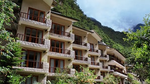 A multi-story hotel with balconies, surrounded by lush greenery and mountains. - Sumaq Machu Picchu Hotel (Machu Picchu)