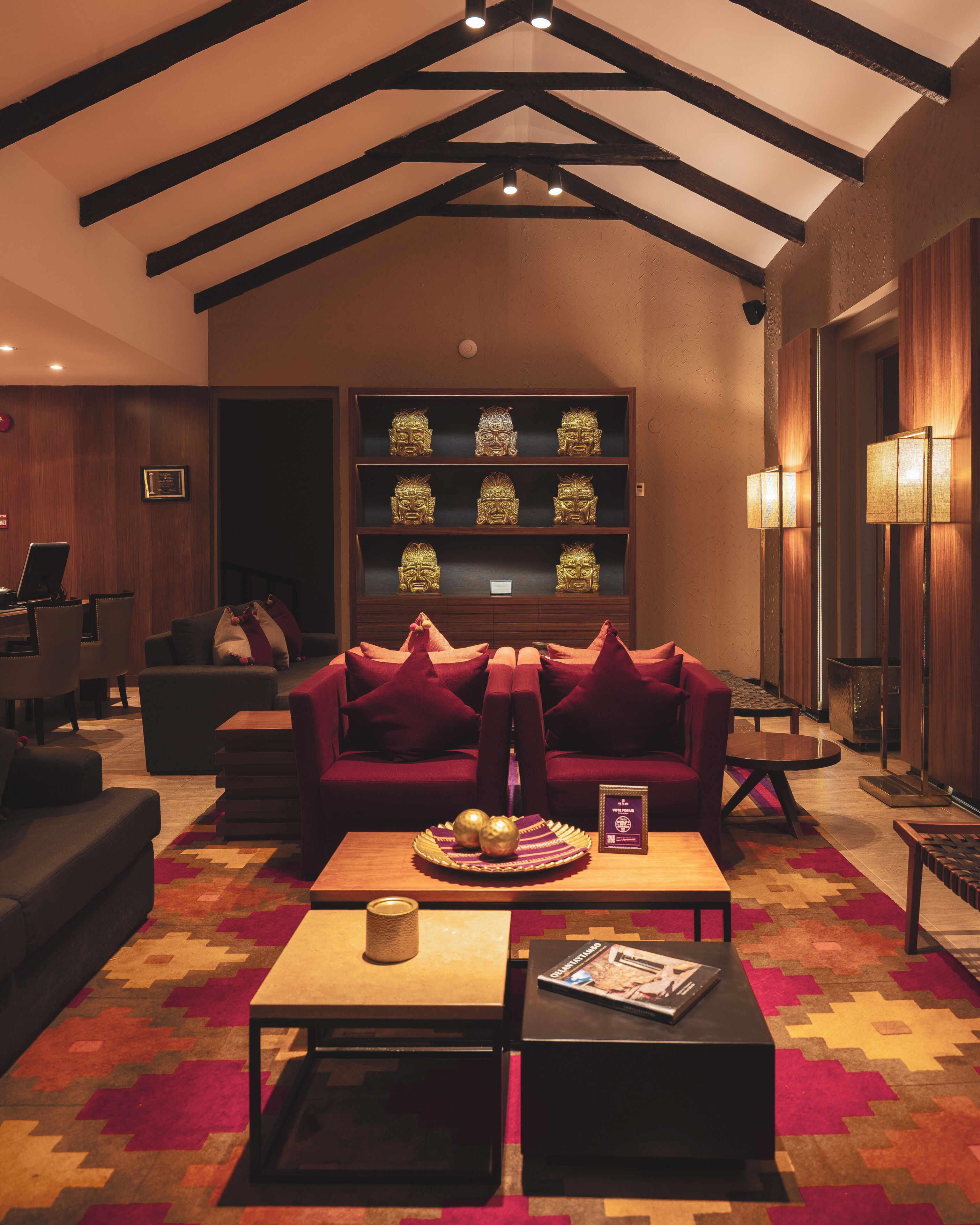 A modern living room with a red sofa, a coffee table, and a bookshelf with decorative items.