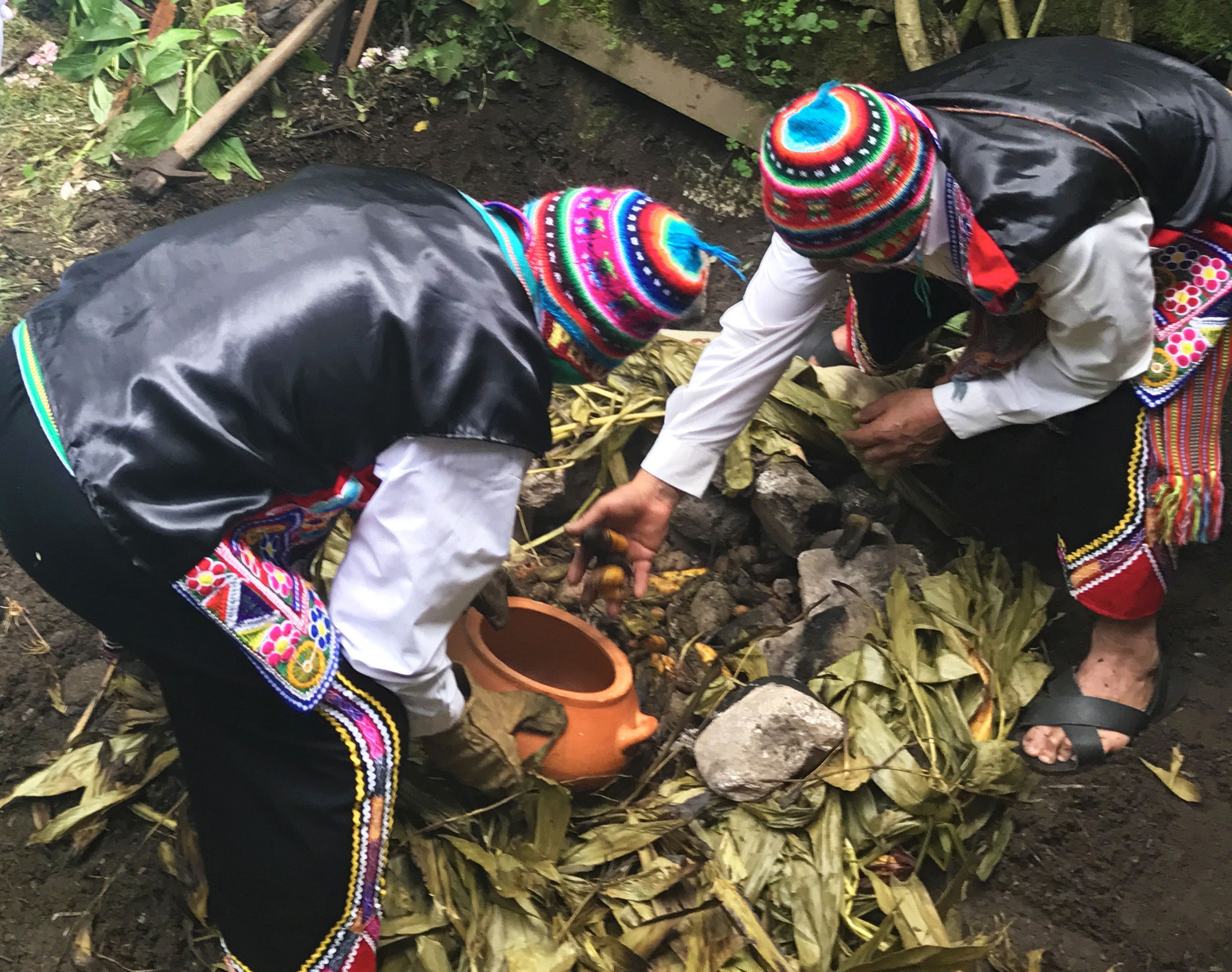 Two individuals engaged in a traditional activity, surrounded by natural elements and tools.