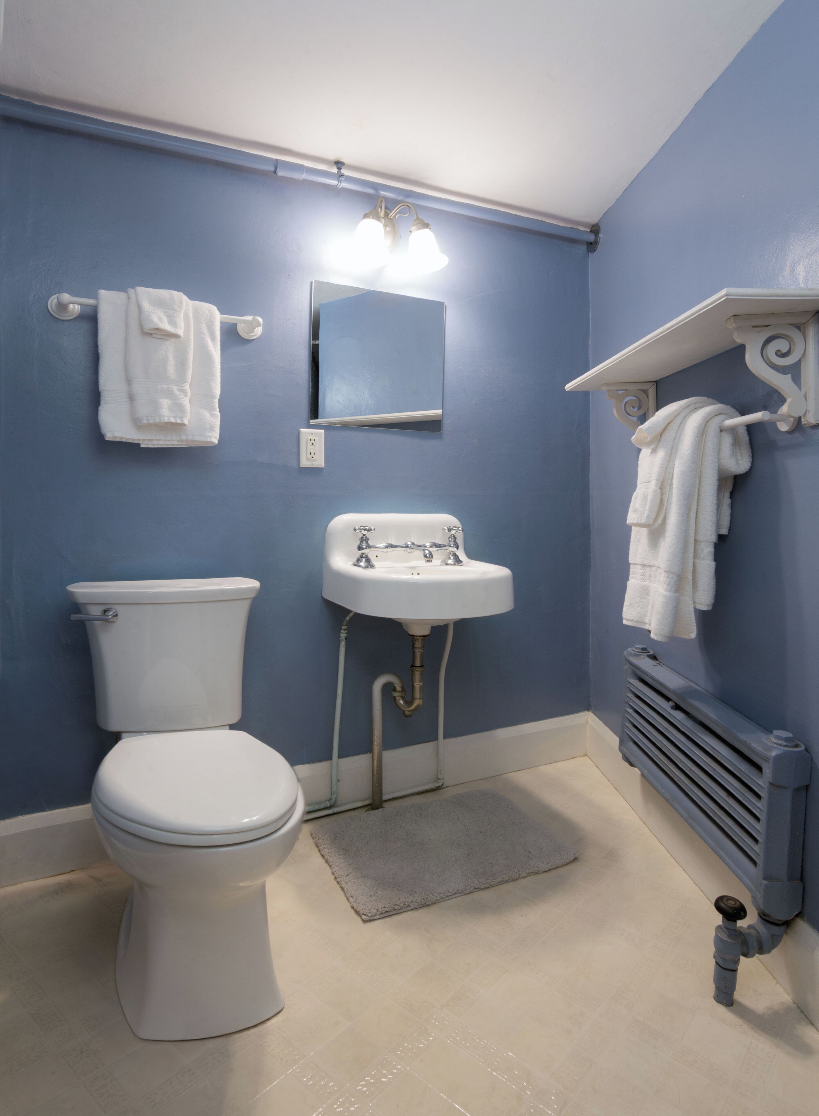 Et badeværelse med toilet, vask og håndklædestang.