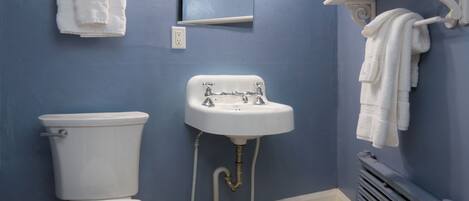 Et badeværelse med toilet, vask og håndklædestang.