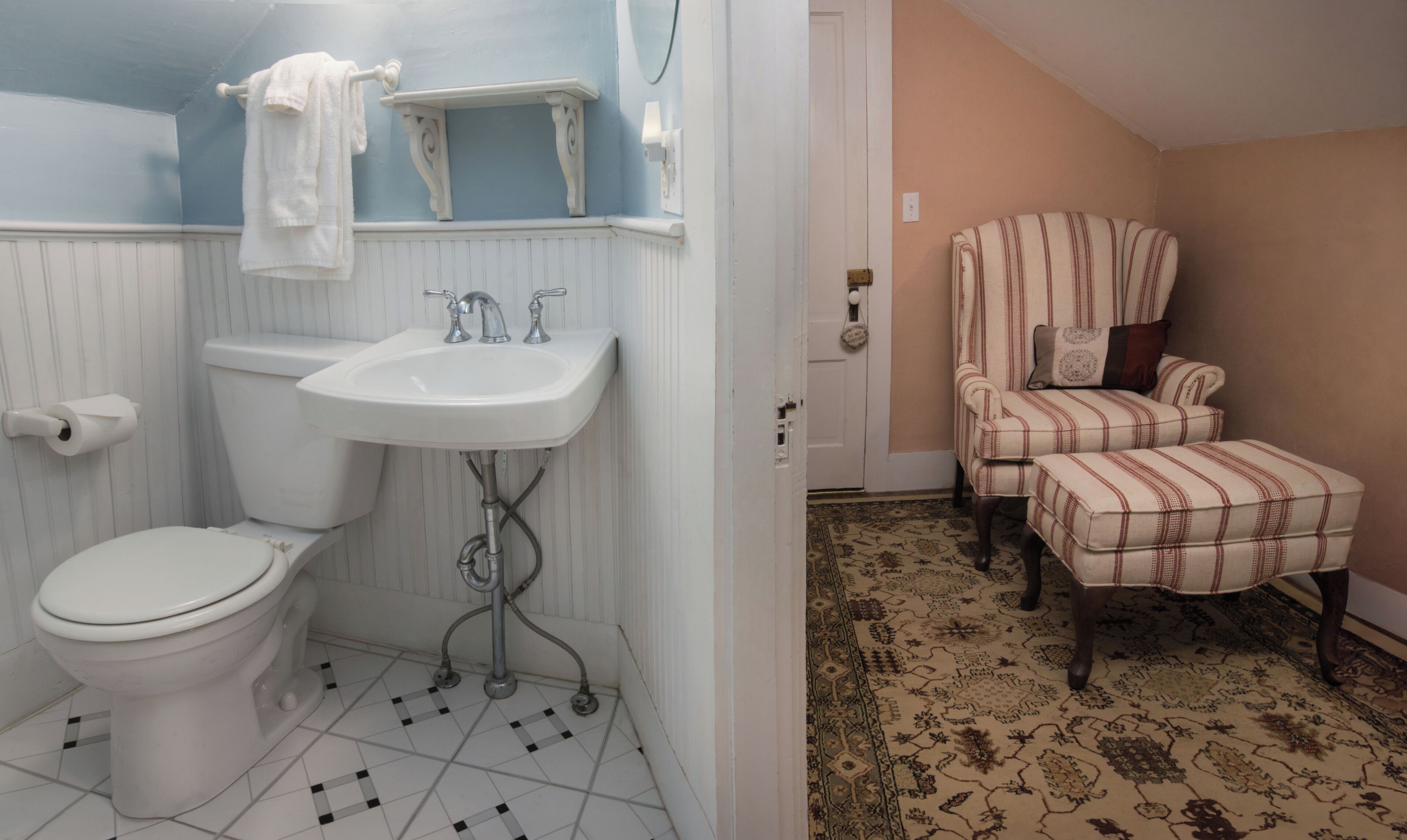 A bathroom with a toilet, sink, and towel rack.