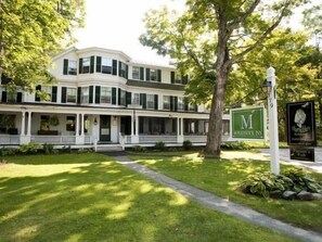 A two-story building with a white facade and green shutters, a covered front porch, and a sign for the "M" Inn. - Monadnock Inn (Jaffrey)
