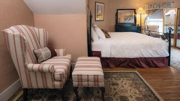 A bedroom with a bed, a chair, a bench, a dresser, and a mirror.