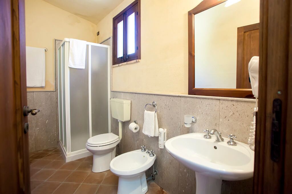 Un baño con ducha, inodoro, bidé, lavabo y espejo.