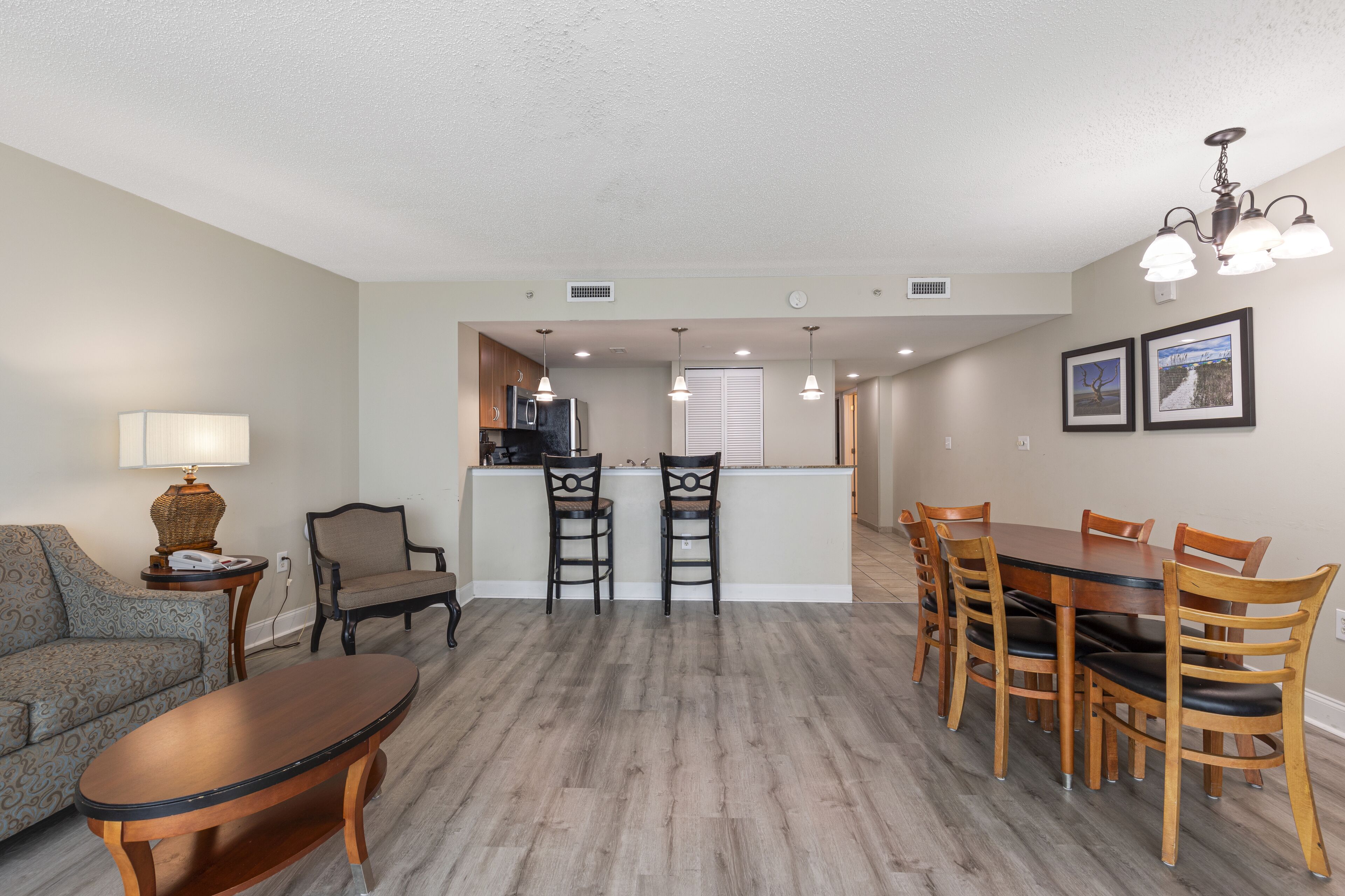 A modern living room with a sofa, a coffee table, and a dining area with a table and chairs.