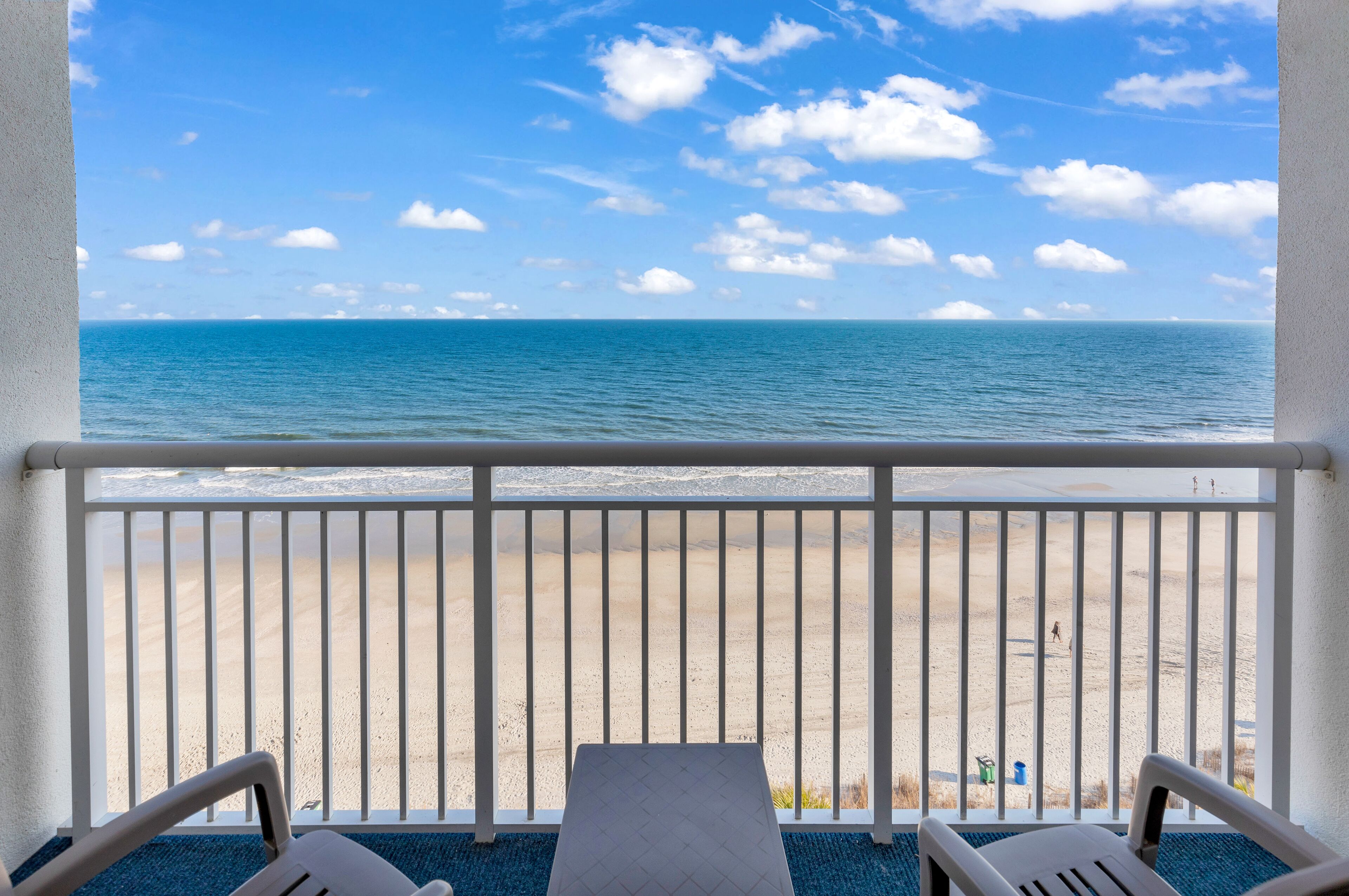 A balcony with a view of a beach and ocean.