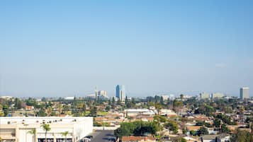 A cityscape with a mix of residential and commercial buildings, a parking lot, and a clear sky.
