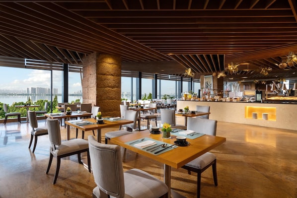 A modern restaurant with a view of a city skyline and a body of water.