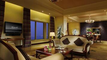 A spacious living room with a sofa, a coffee table, and a TV mounted on the wall.