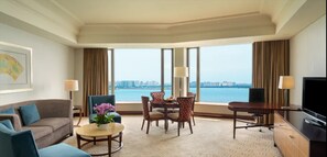 Enjoy a city view from the large window, with a sofa set, dining table, and desk in this stylish room.