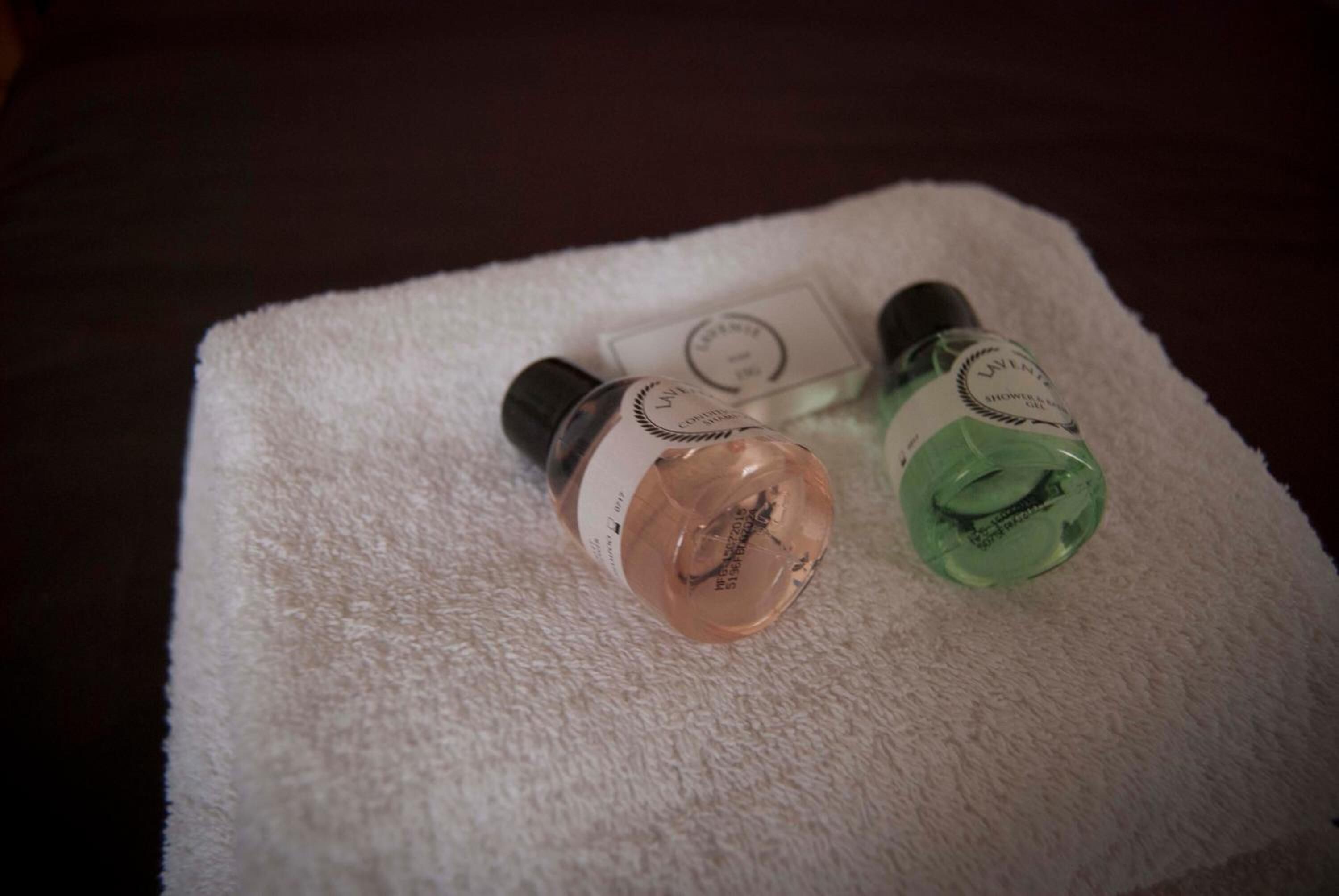 Two bottles of liquid on a white towel.
