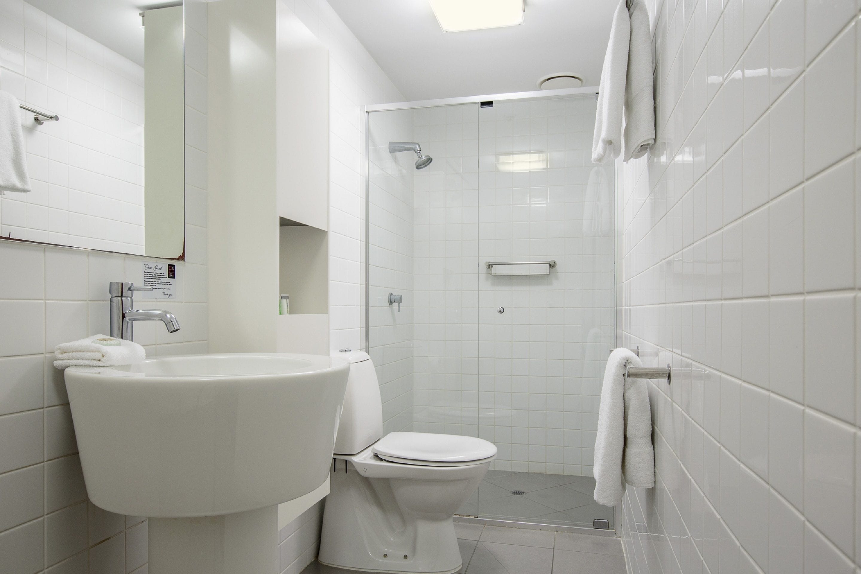 Uma casa de banho moderna com lavatório, sanita e chuveiro.