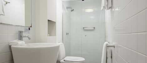 A modern bathroom with a sink, toilet, and shower.