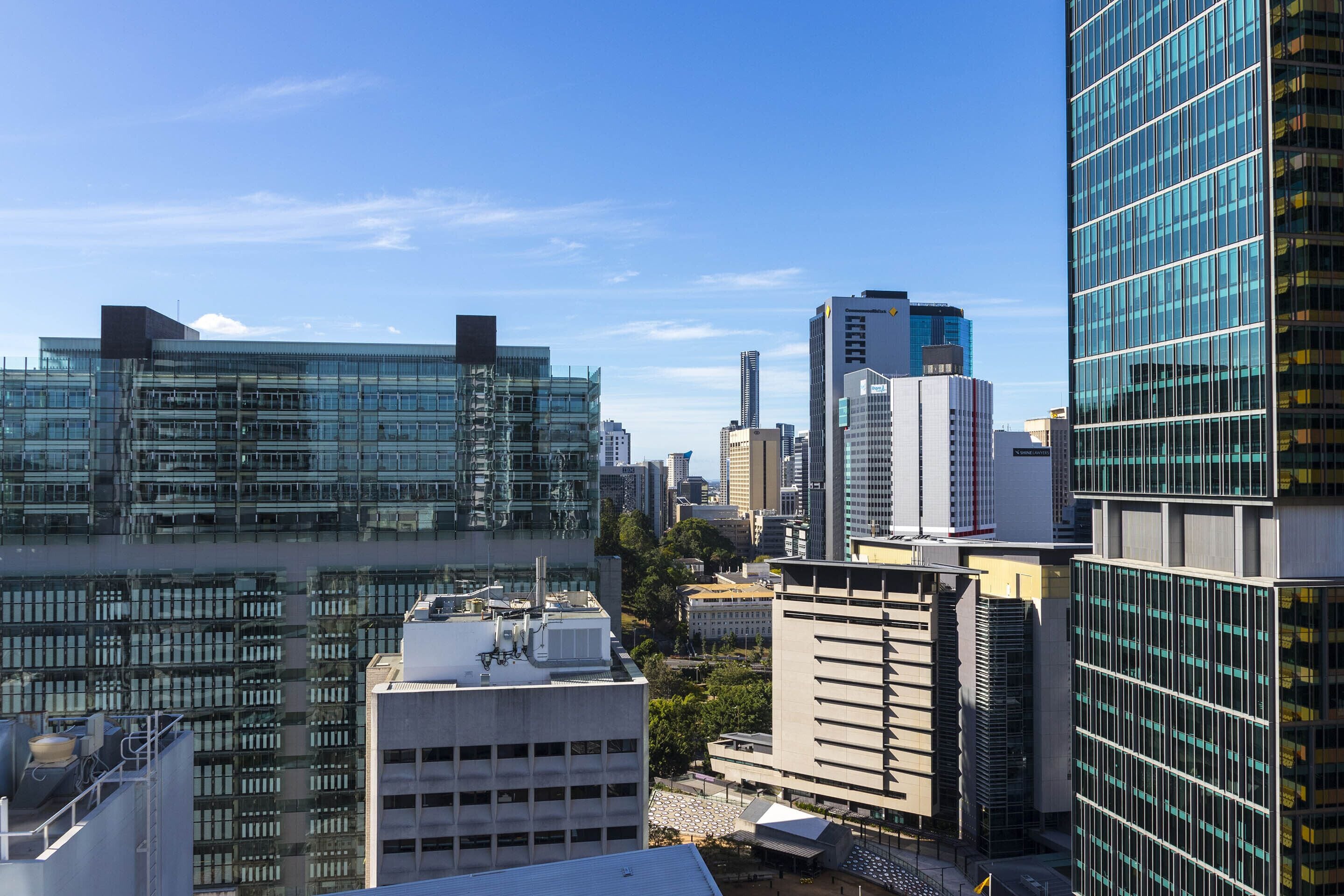 Un paisaje urbano con edificios modernos de gran altura, incluyendo una estructura con fachada de vidrio y una variedad de estilos arquitectónicos.