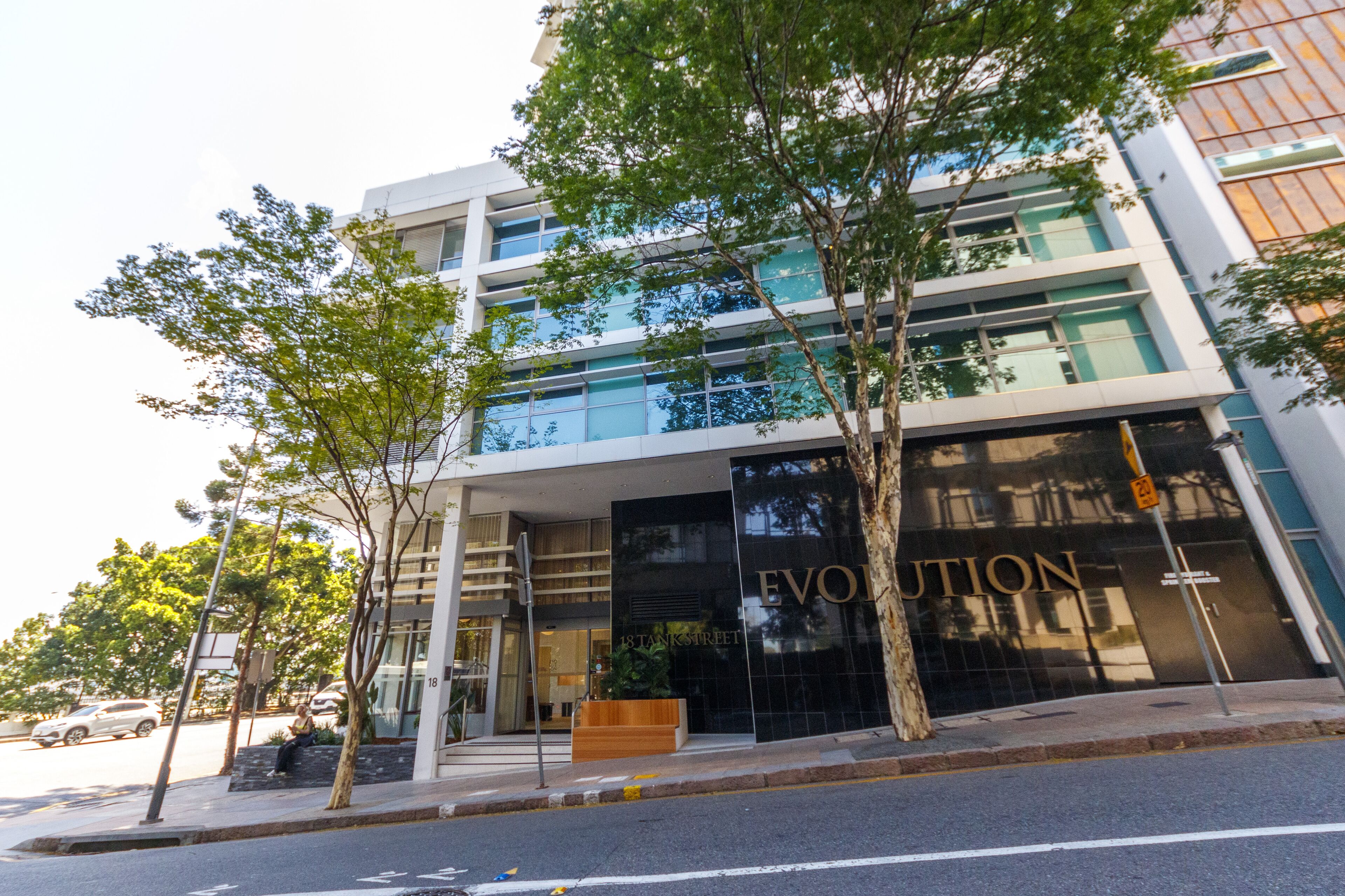 A modern building with a glass facade and the name "EVOLUTION" on the entrance.