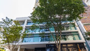 A modern building with a glass facade, a visible entrance, and a sign reading "EVOLUTION". - Evolution Apartments (Brisbane)