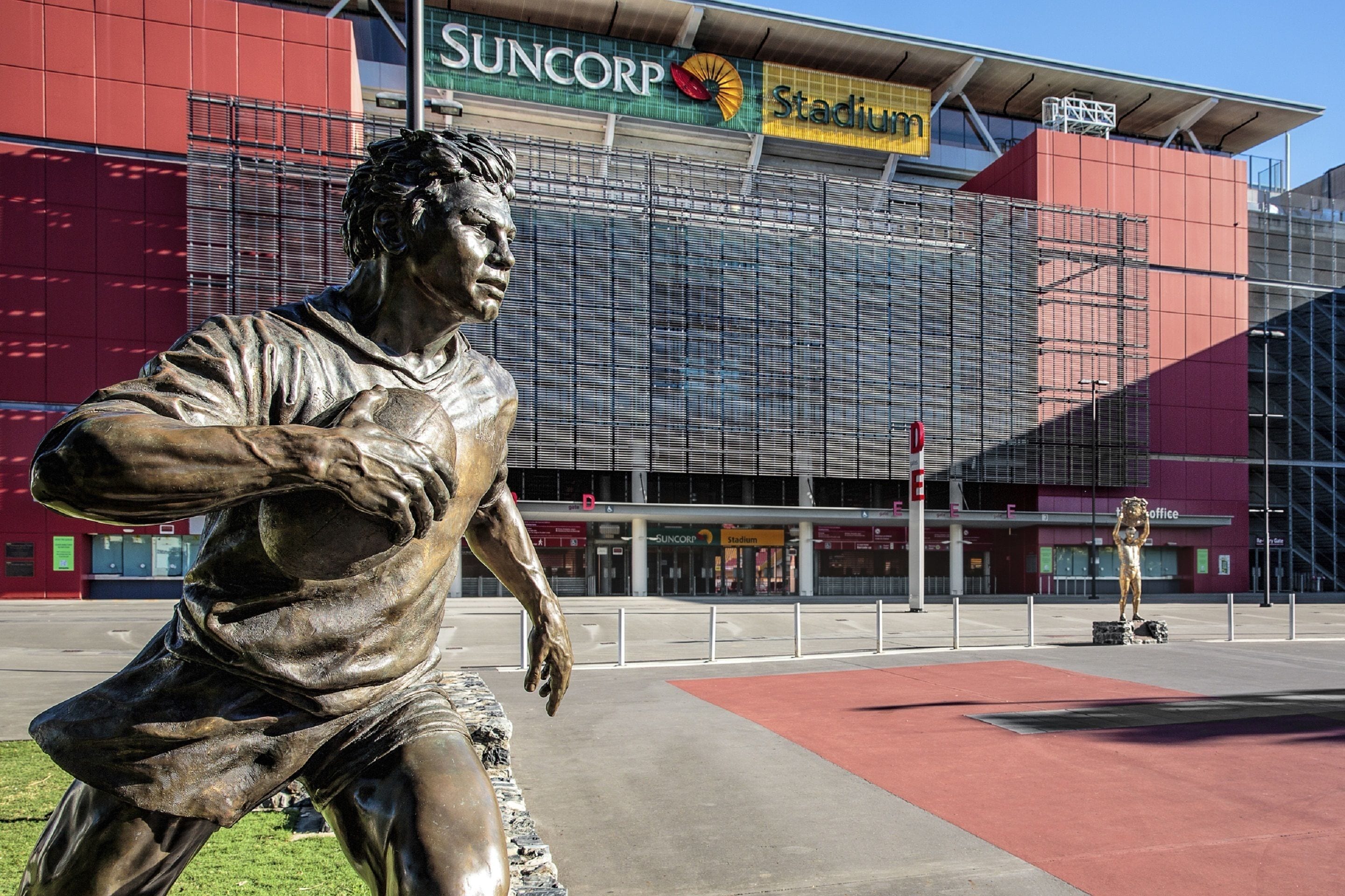 A stadium with a large bronze statue of a football player in a kicking pose.