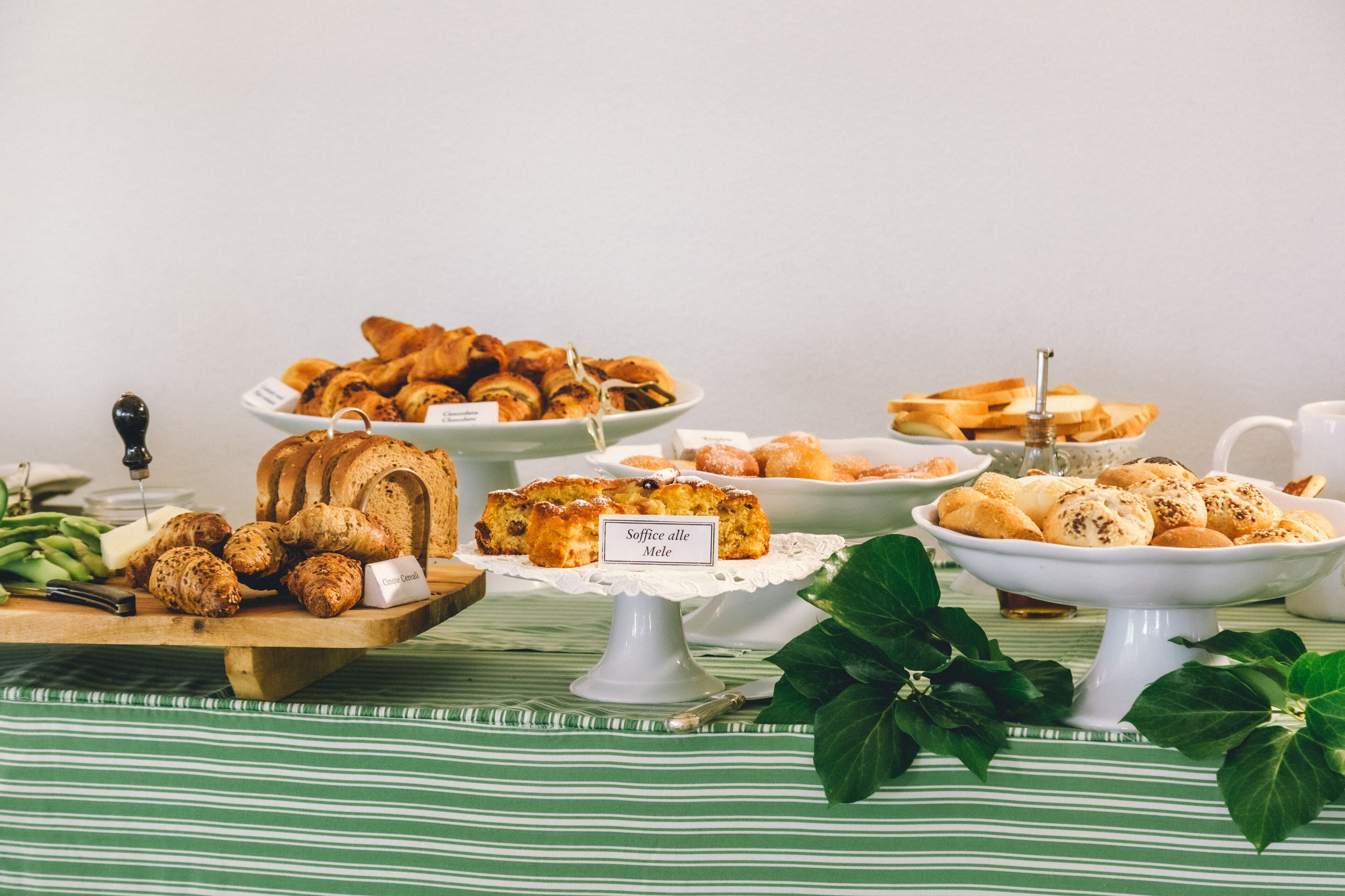 A variety of baked goods on a table with a green and white striped tablecloth.