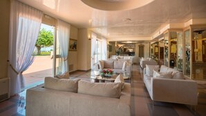 Amplia sala de estar con un conjunto de sofás, una mesa de centro y vistas al exterior.