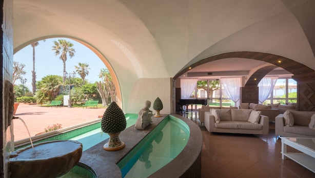 Un amplio salón con piscina, asientos cómodos y vistas al exterior.