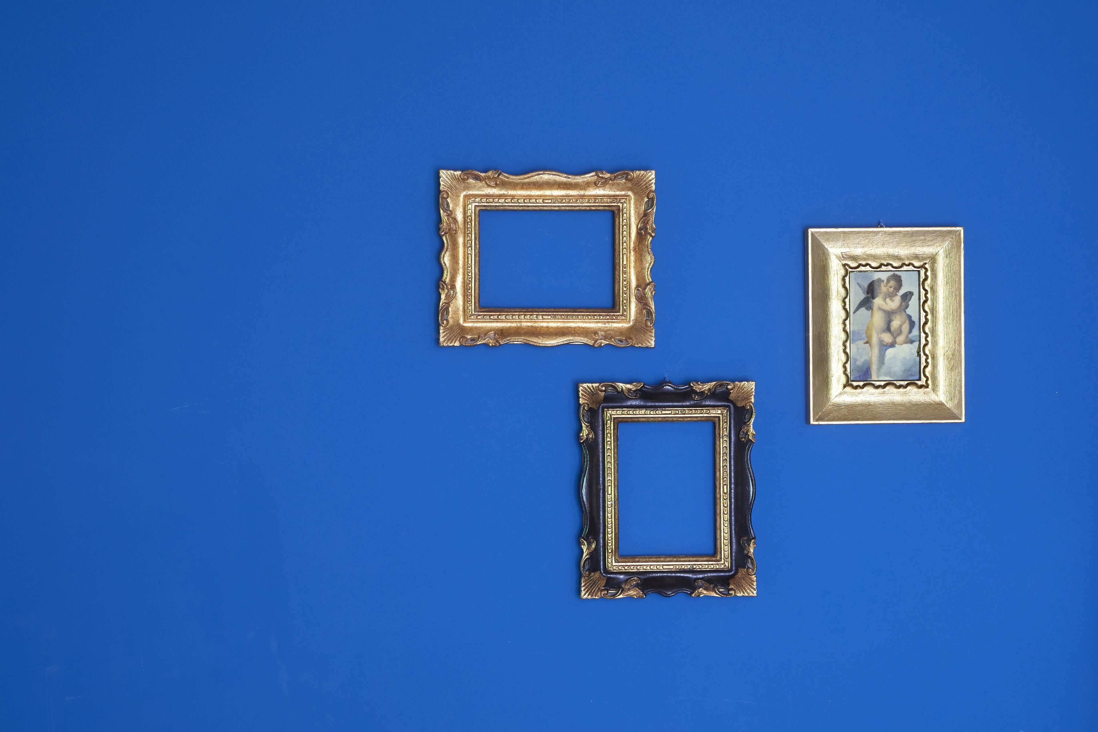Three square picture frames with ornate designs on a blue background.