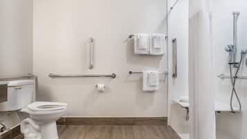 A modern bathroom with a toilet, bidet, and shower area, equipped with grab bars and a towel rack.