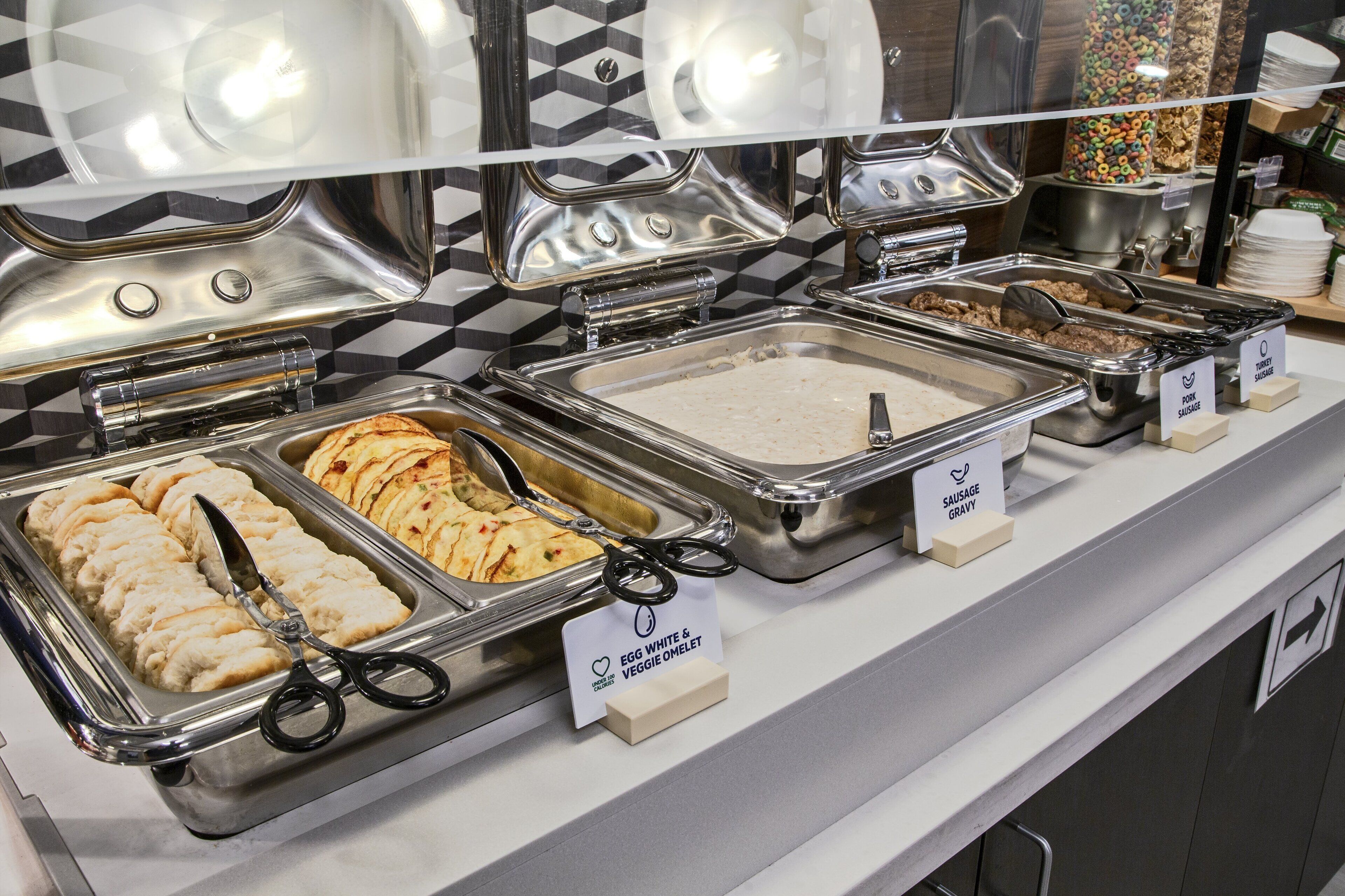 A buffet with various food options including egg white & veggie omelet, sausage gravy, and other dishes.