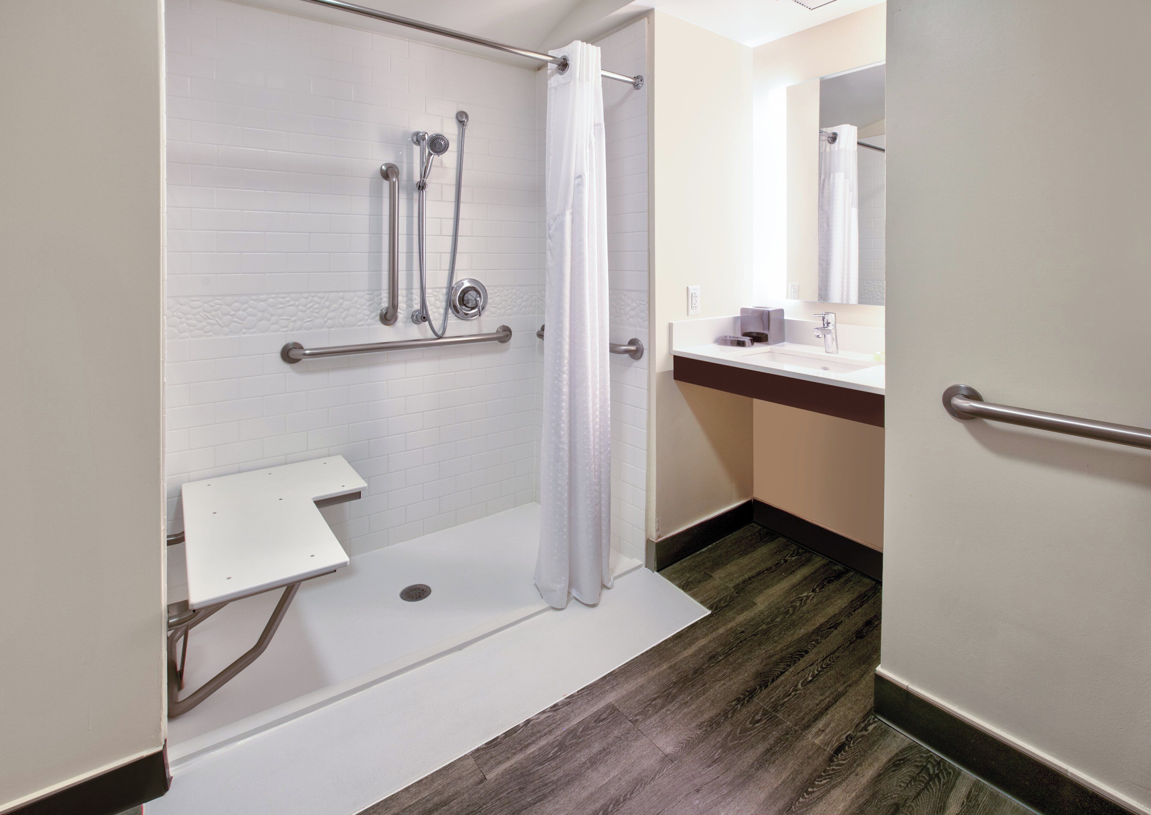 A bathroom with a shower, a toilet, and a sink.