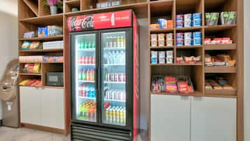 Uma máquina de vendas automática e um refrigerador de Coca-Cola numa loja.