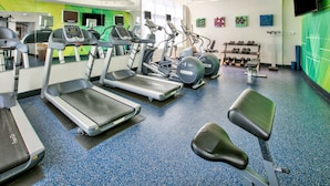 Un gimnasio con cintas de correr, elípticas y pesas sueltas.