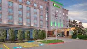 Un hotel Holiday Inn con fachada moderna, varios pisos y un estacionamiento con acceso para discapacitados.