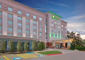 Un hotel Holiday Inn con fachada moderna, varios pisos y un estacionamiento con acceso para discapacitados.