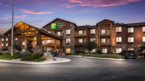 A Holiday Inn Express building with a stone facade, multiple balconies, and a covered entrance. - Holiday Inn Express Hotel & Suites Custer by IHG (Custer)