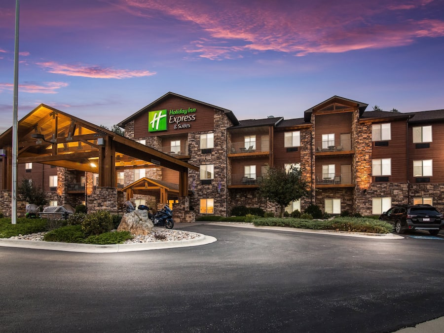 A Holiday Inn Express building with a stone facade, multiple balconies, and a covered entrance.