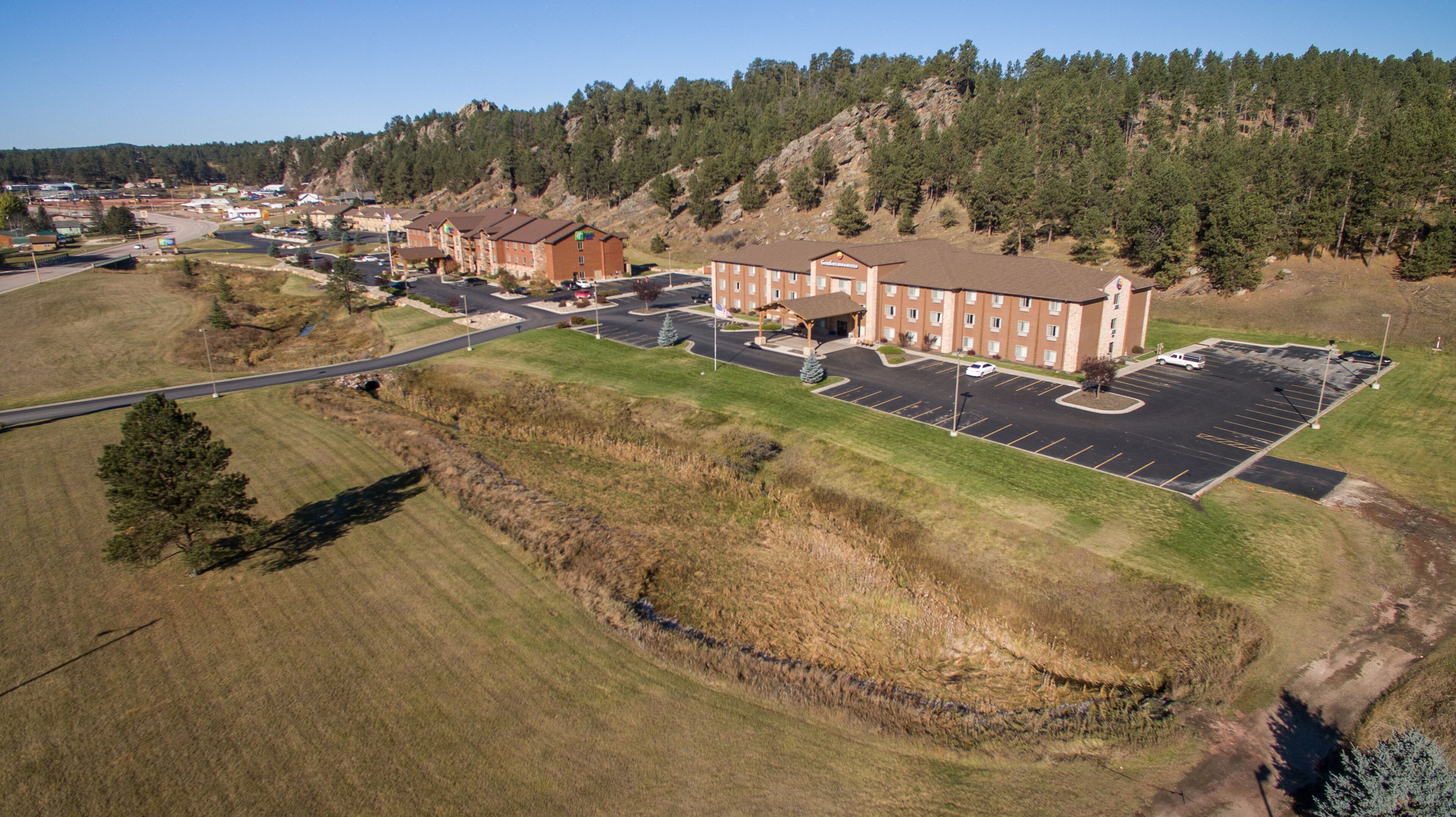 A large building with a parking lot and a road leading to it.