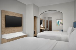 A modern hotel room with two beds, a flat-screen TV mounted on a wooden panel, a desk with a chair, and a small bathroom visible through an archway. - Holiday Inn Express Hotel & Suites DFW West - Hurst by IHG (Hurst)