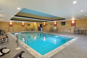Piscina com várias pistas de natação, avisos de segurança e espreguiçadeiras.