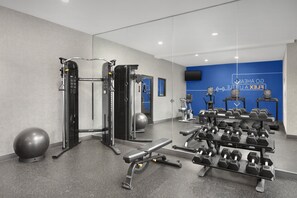 A gym with exercise equipment, a bench, and dumbbells. - Holiday Inn Express Hotel & Suites DFW West - Hurst by IHG (Hurst)