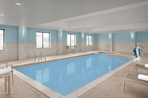 A large indoor swimming pool with clear water, surrounded by beige tiles and blue walls. - Holiday Inn Express Hotel & Suites DFW West - Hurst by IHG (Hurst)