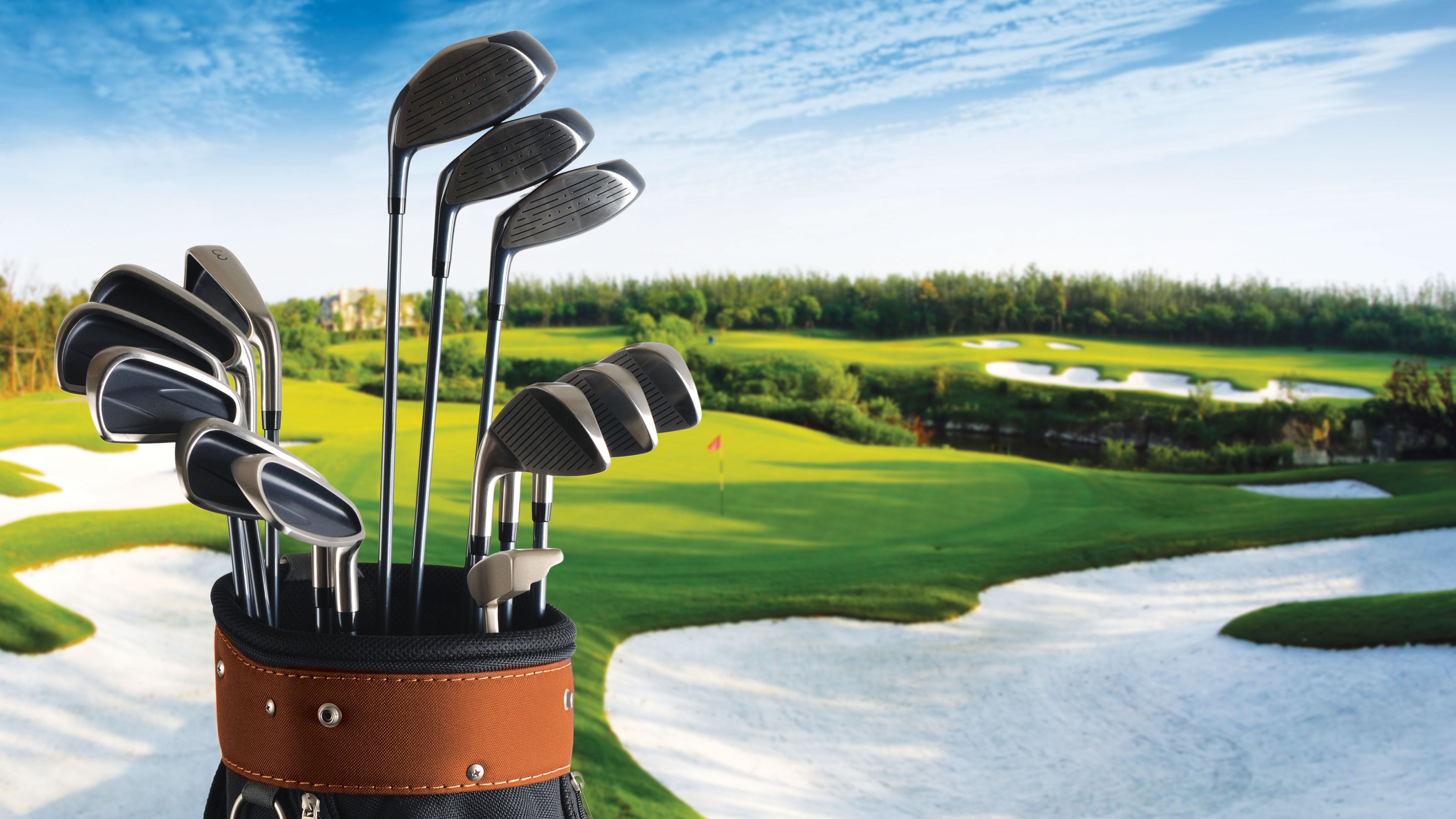 A golf bag with multiple clubs on a golf course.