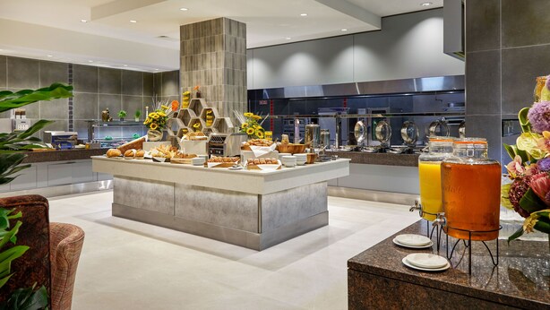 A modern kitchen with a central island, a buffet setup, and a juice dispenser. - Crowne Plaza Hotel Blanchardstown by IHG (Dublin)