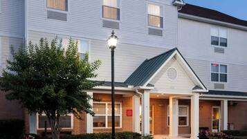 TownePlace Suites by Marriott hotel exterior with a brick facade, large windows, and a well-maintained garden area.