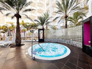 A hot tub surrounded by palm trees and lounge chairs in a hotel atrium. - Servatur Don Miguel - Adults Only (San Bartolomé de Tirajana)